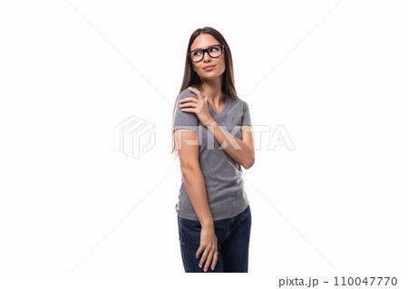 charming brunette leader woman dressed in a gray t-shirt wears eyeglasses charming brunette leader woman dressed in a gray t-shirt wears eyeglasses 110047770
