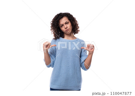 a slender young lady with black curly hair dressed in a light blue sweater is experiencing emotions a slender young lady with black curly hair dressed in a light blue sweater is experiencing emotions 110047877