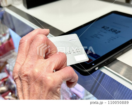 タブレット端末上でクレジットカード決済をする高齢女性の手元 タブレット端末上でクレジットカード決済をする高齢女性の手元 110050889