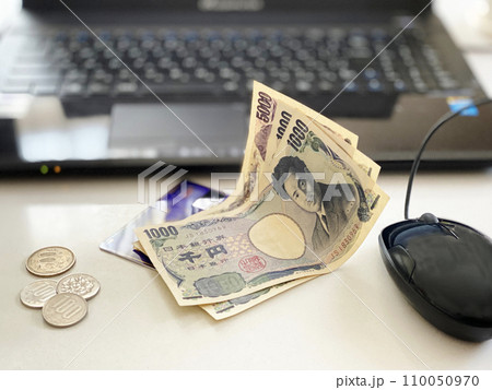 ノートパソコンの前にお金とクレジットカード ノートパソコンの前にお金とクレジットカード 110050970