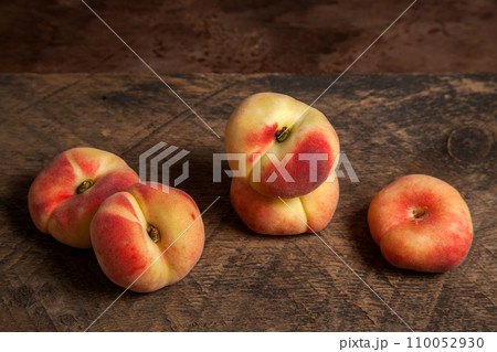 Several saturn peaches or flat peaches on wooden background.. Several saturn peaches or flat peaches on wooden background.. 110052930