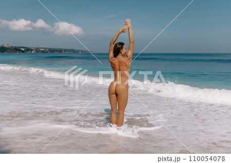 Naked sporty woman with perfect body relaxing on sunny beach. Sexy model enjoying at tropical beach Naked sporty woman with perfect body relaxing on sunny beach. Sexy model enjoying at tropical beach 110054078