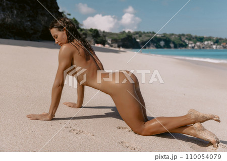 Woman with tanned sporty body relaxing on ocean beach. Sexy model enjoying at tropical beach 110054079
