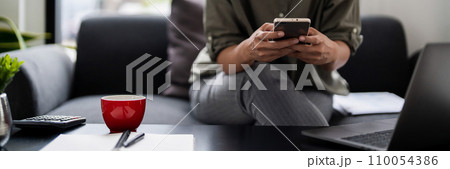 Asian casual businesswoman sits on couch to reading growth finance new startup report on smartphone Asian casual businesswoman sits on couch to reading growth finance new startup report on smartphone 110054386