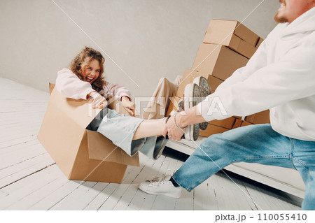 Happy young family couple man carry woman inside box. Moving with cardboard boxes to new estate home apartment concept 110055410