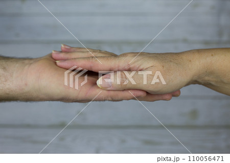 Male hand of the older husband lies on the palm of the adult wife. Concept of love and relationships at age, close photo of hands 110056471