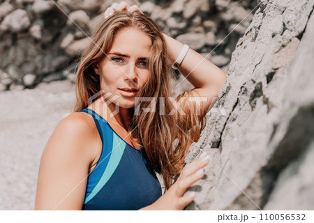 Woman summer travel sea. Happy tourist in blue bikini enjoy taking picture outdoors for memories. Woman traveler posing on the beach surrounded by volcanic mountains, sharing travel adventure journey Woman summer travel sea. Happy tourist in blue bikini enjoy taking picture outdoors for memories. Woman traveler posing on the beach surrounded by volcanic mountains, sharing travel adventure journey 110056532