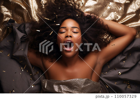 African american woman having orgasm. Woman with open mouth and closed eyes enjoying sex lying among flying glitter and sparkles as a symbol of orgasm. Sexual experience, masturbation, cunnilingus. 110057329