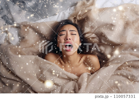 Young asian woman having orgasm. Woman with open mouth and closed eyes enjoying sex lying among flying glitter and sparkles as a symbol of orgasm. Sexual experience, masturbation, cunnilingus. Young asian woman having orgasm. Woman with open mouth and closed eyes enjoying sex lying among flying glitter and sparkles as a symbol of orgasm. Sexual experience, masturbation, cunnilingus. 110057331