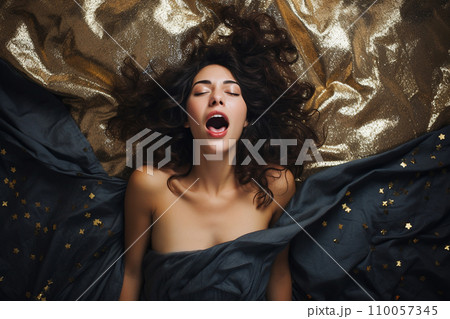 Young european woman having orgasm. Woman with open mouth and closed eyes enjoying sex lying among flying glitter and sparkles as a symbol of orgasm. Sexual experience, masturbation, cunnilingus. 110057345