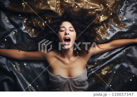 Young european woman having orgasm. Woman with open mouth and closed eyes enjoying sex lying among flying glitter and sparkles as a symbol of orgasm. Sexual experience, masturbation, cunnilingus. Young european woman having orgasm. Woman with open mouth and closed eyes enjoying sex lying among flying glitter and sparkles as a symbol of orgasm. Sexual experience, masturbation, cunnilingus. 110057347