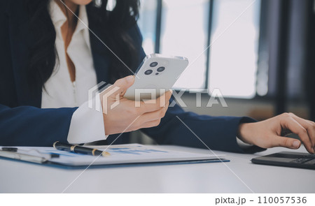 Financial analysts analyze business financial reports on a digital tablet planning investment project during a discussion at a meeting of corporate showing the results of their successful teamwork. 110057536
