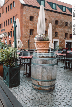 Traditional wooden barrel on street outdoors at city cafe. Wine making 110057820