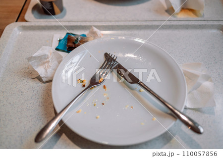 Dirty plates and utensils on a plastic tray in a cafe or restaurant 110057856