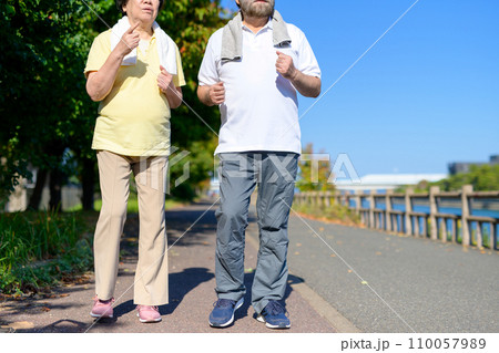 健康のためにウォーキングするアクティブシニアの男女夫婦　ダイエット　運動　健康習慣　散歩　 110057989