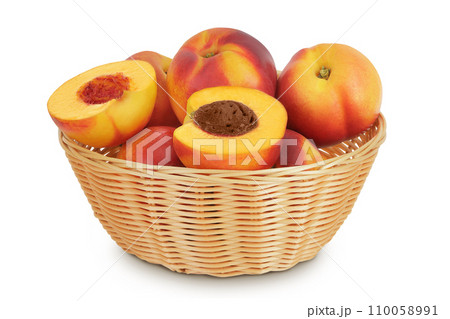 Ripe nectarine fruit with half in a wicker basket isolated on white background with full depth of field 110058991