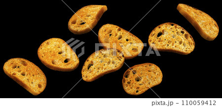 Falling bruschetta crackers, bread croutons on black background  110059412