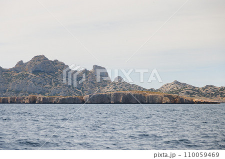 Rocky island with a high cliff, view from the sea. Rocky island with a high cliff, view from the sea. 110059469