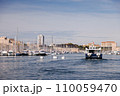A ship is sailing in the port of Marseille. 110059470
