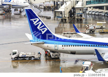雨の空港　旅客機とハイリフトローダー　沖縄県那覇市 110059556