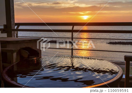 夕暮れの日本海　夕陽（夕日）と露天風呂　新潟県村上市 110059591