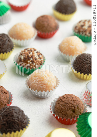 Typical Brazilian sweet brigadeiro. Assorted flavors of candies on a white table Typical Brazilian sweet brigadeiro. Assorted flavors of candies on a white table 110059711