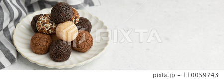 Typical Brazilian sweet brigadeiro. A heap of assorted flavors of candies on a white table with copy space Typical Brazilian sweet brigadeiro. A heap of assorted flavors of candies on a white table with copy space 110059743