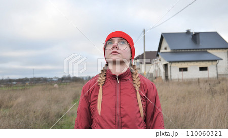 Portrait of a teenage girl in glasses wearing red clothes outside in the fall. Portrait of a teenage girl in glasses wearing red clothes outside in the fall. 110060321