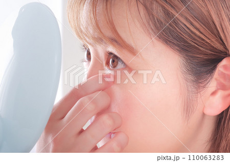 目を気にする若い女性 110063283