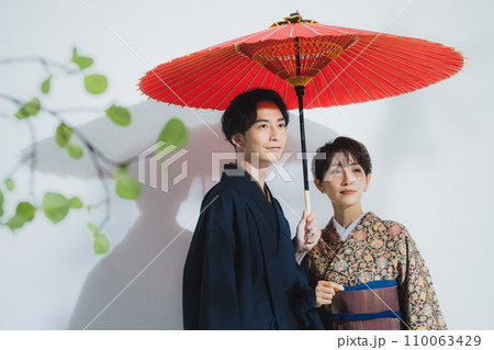 番傘をさした着物姿の男女 110063429