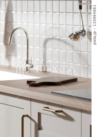A bright beige-toned kitchen interior with sunlight coming through the window. 110064861