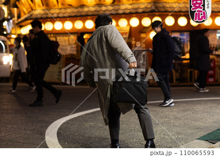 夜の繁華街で酔っ払う男性 110065593