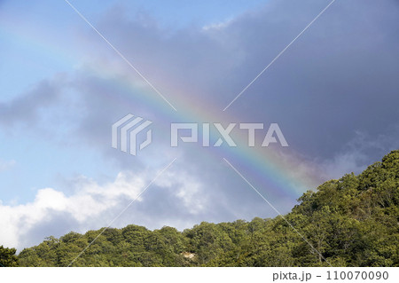 青空と山の稜線に架かった虹 青空と山の稜線に架かった虹 110070090