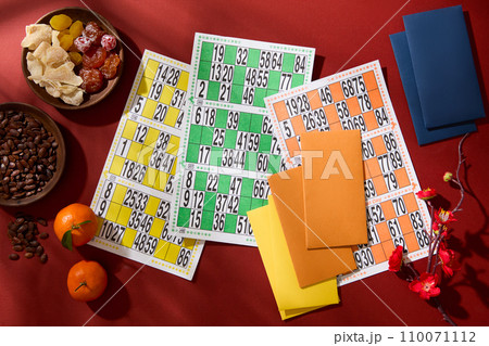The lotto set is displayed on the table with melon seeds, salted dry apricot, tangerines, peach blossoms and lucky money envelopes. Game for the beginning of the year. 110071112