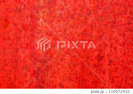 Red metal and paint creating textured wall background 110072410