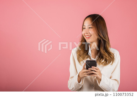 Happy Asian portrait beautiful cute young woman teen smiling excited hold smart mobile phone studio shot isolated on pink background, Female surprised and sms chatting internet online on smartphone Happy Asian portrait beautiful cute young woman teen smiling excited hold smart mobile phone studio shot isolated on pink background, Female surprised and sms chatting internet online on smartphone 110073352