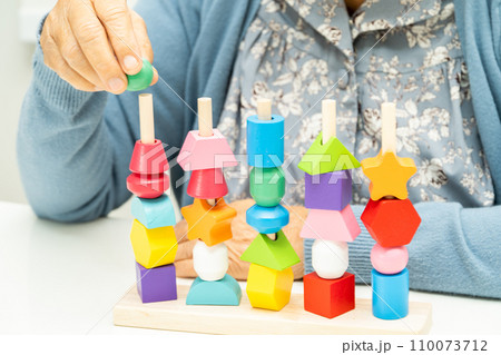 Alzheimer disease AD, Asian elderly woman patient suffering from dementia learn practical motor skills rehabilitation. Alzheimer disease AD, Asian elderly woman patient suffering from dementia learn practical motor skills rehabilitation. 110073712