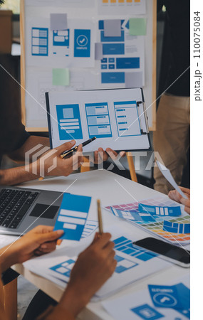 Close up ux developer and ui designer use augmented reality brainstorming about mobile app interface wireframe design on desk at modern office.Creative digital development agency 110075084