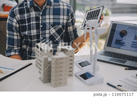 Electrical engineer with businessman discussing new project installation solar cell panel on the roof of building. Alternative energy concept. 110075117