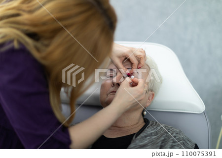 A relaxed woman enjoys the services of a beautician. A relaxed woman enjoys the services of a beautician. 110075391