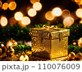 Christmas gift box with golden baubles on bokeh background 110076009