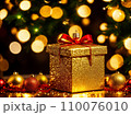 Christmas gift box with golden baubles on bokeh background 110076010