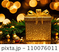Christmas gift box with golden baubles on bokeh background 110076011
