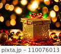 Christmas gift box with golden baubles on bokeh background 110076013