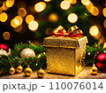 Christmas gift box with golden baubles on bokeh background 110076014