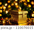 Christmas gift box with golden baubles on bokeh background 110076015
