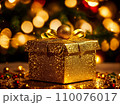 Christmas gift box with golden baubles on bokeh background 110076017