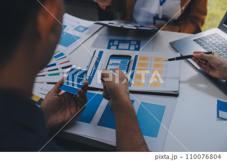 Close up ux developer and ui designer use augmented reality brainstorming about mobile app interface wireframe design on desk at modern office.Creative digital development agency 110076804