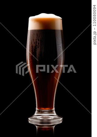 Beer in a tall glass on a dark black background. Mugs with drink like Ipa, Pale Ale, Pilsner, Porter or Stout 110080094