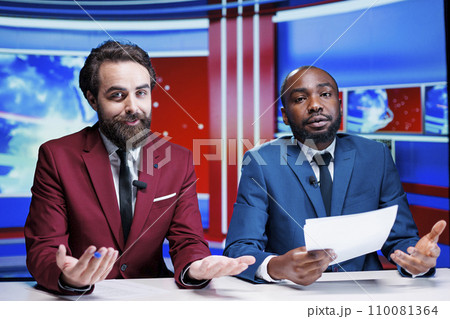 Morning show tv hosts reading headlines in newsroom, debating latest global information about daily events. Diverse team of reporters delivering newscast live with all important topics. Morning show tv hosts reading headlines in newsroom, debating latest global information about daily events. Diverse team of reporters delivering newscast live with all important topics. 110081364